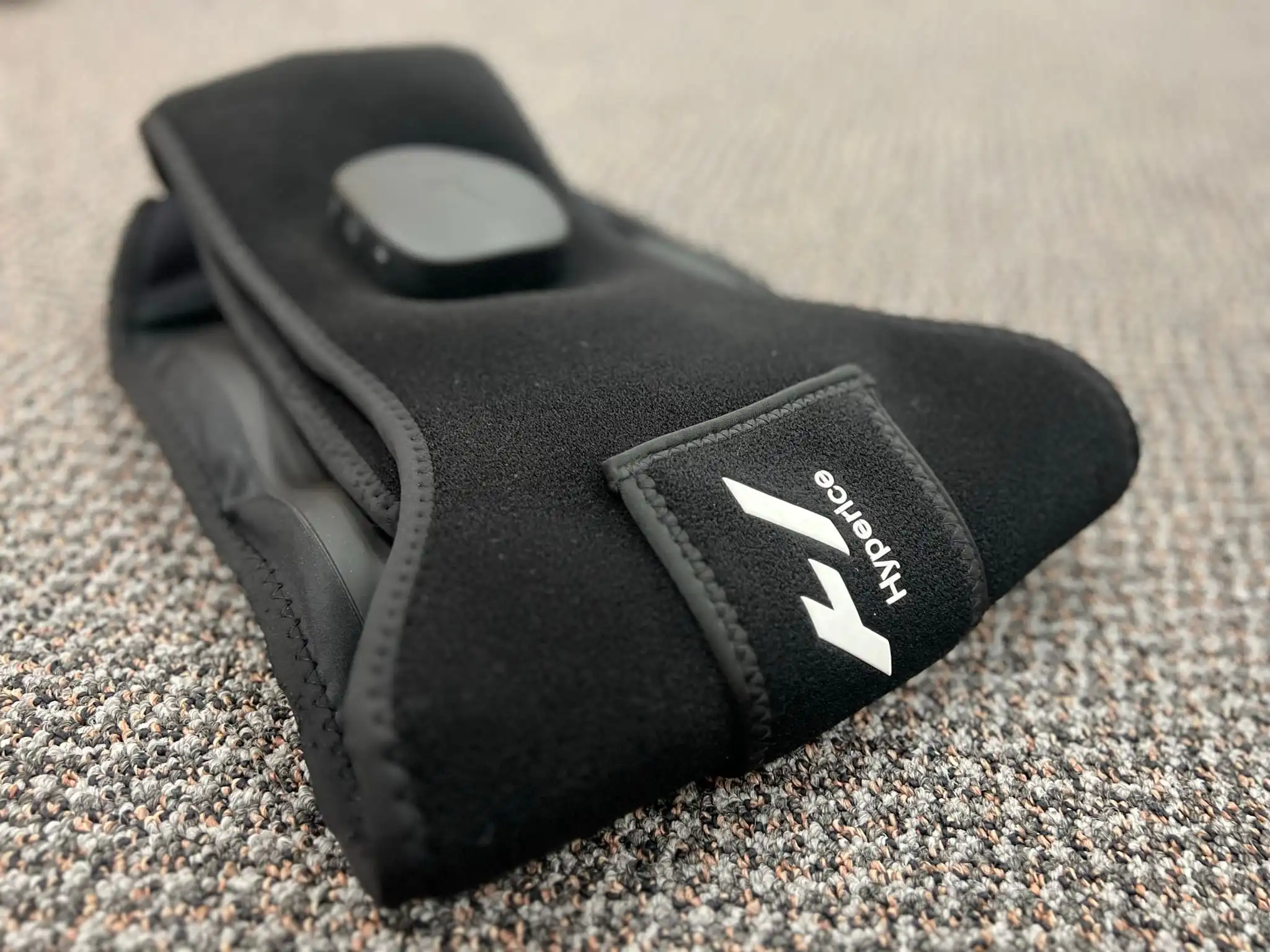 Hyperice Venom 2 Back wearable wrap folded on carpet