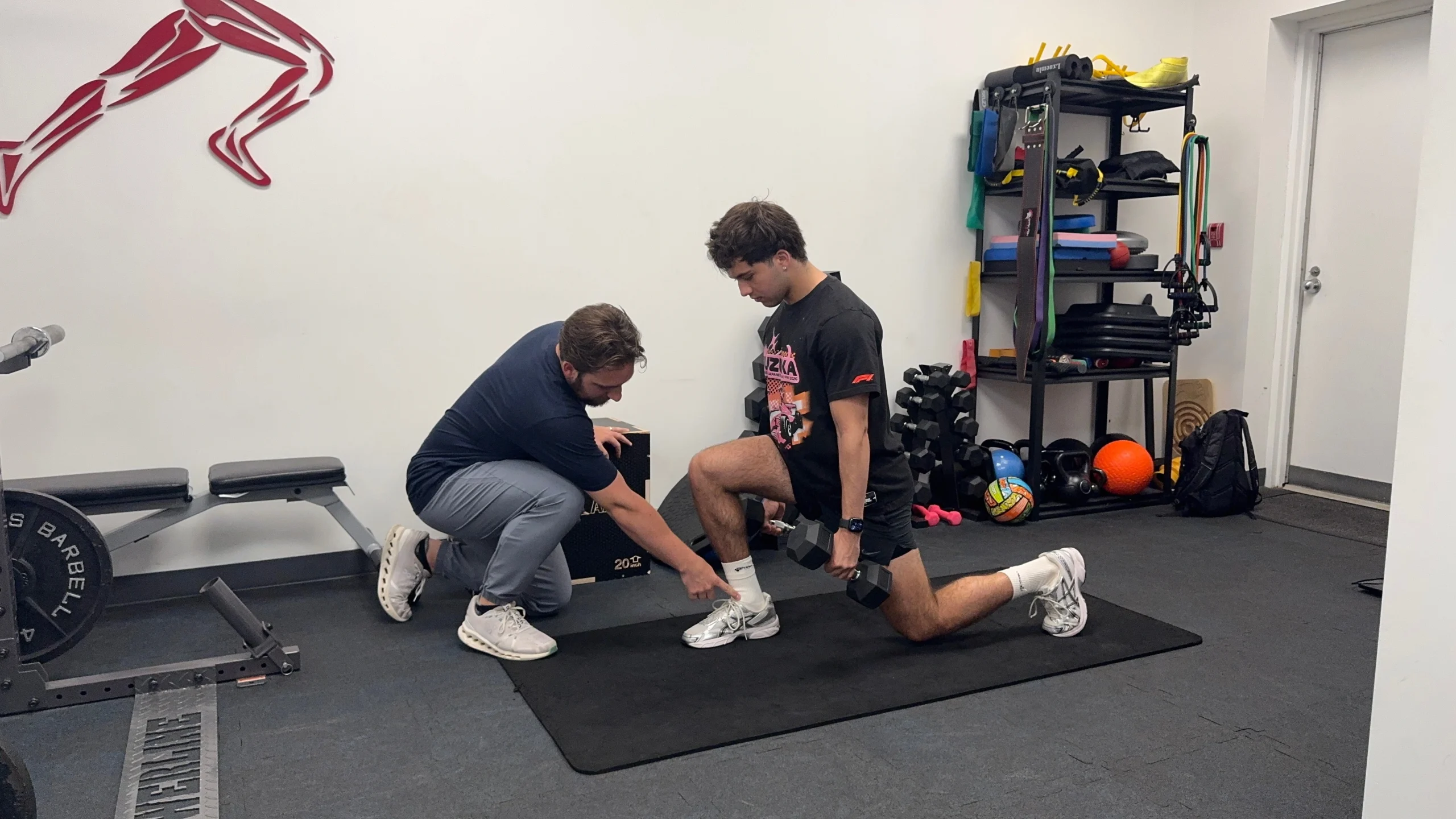 Dr Maxwell Warren assessing lower body strength and mobility for a baseball and softball athlete